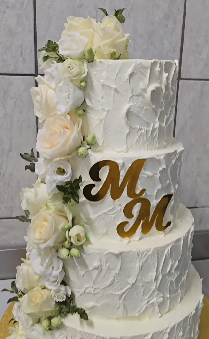 Four-tier ivory cake with cascading white roses